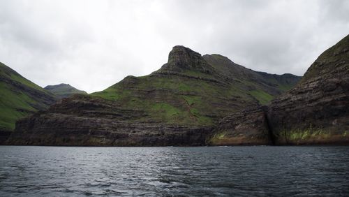 Scenic view of lake by mountains against sky
