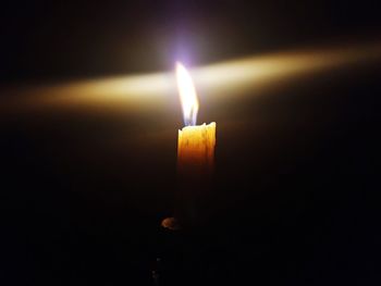 Close-up of burning candle in darkroom