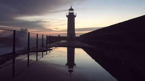 Reflection of tower in sea at sunset