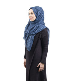 Portrait of young woman standing against white background