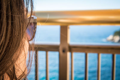 Close-up of woman by railing against sea