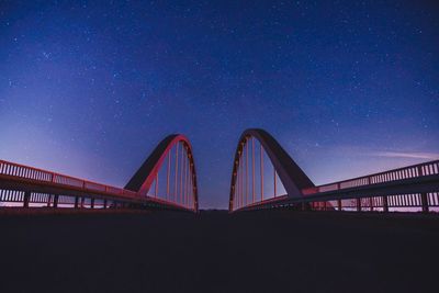 Diminishing perspective of bridge against star field at night