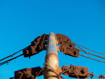 Low angle view of telephone pole against blue sky