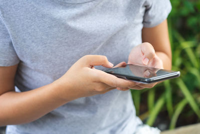 Midsection of man using mobile phone