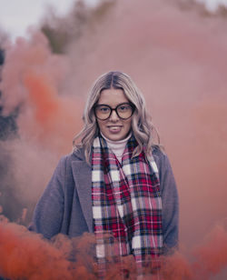 Portrait of young woman standing against sky