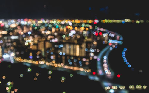 Defocused image of illuminated cityscape at night