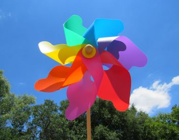 Low angle view of pinwheel against blue sky