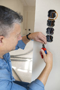 Side view of man holding thermometer