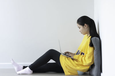 Side view of young woman looking at camera