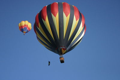 Low angle view of hot air balloon against clear blue sky