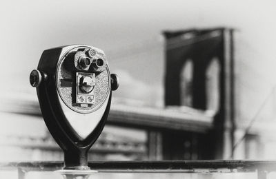 Close-up of coin-operated binoculars with brooklyn bridge in background