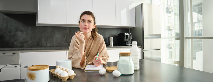 Portrait of young woman using mobile phone at home