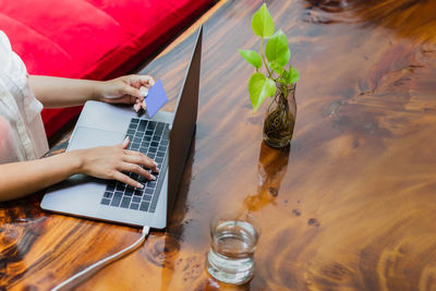 Midsection of woman using laptop on table