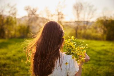 Rear view of woman with flowers