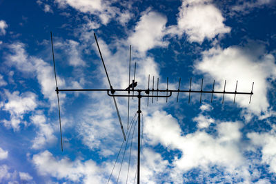 Low angle view of silhouette electricity pylon against sky