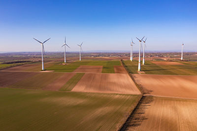 Agricultural fields with windmills and wind turbines seen from the air with a drone