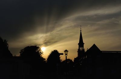 Silhouette buildings against sky at sunset
