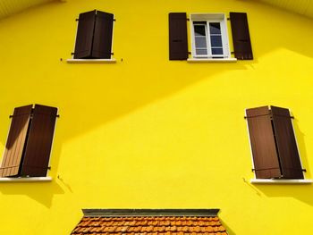 Low angle view of yellow building with windows. 