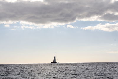 Sailboat sailing on sea against sky