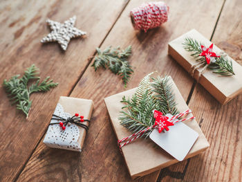 Christmas diy presents wrapped in craft paper with fir tree twigs. new year gifts on wooden table.