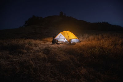 Tent on field against sky at night