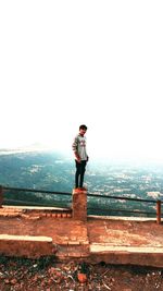 Full length of man standing on mountain against clear sky