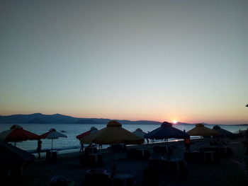 Scenic view of beach against clear sky at sunset