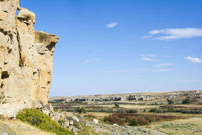 Rock formations on landscape against blue sky