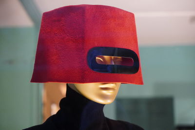 Close-up of mannequin face covered with red box