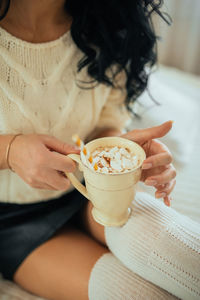 Midsection of woman holding ice cream