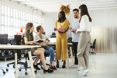 Colleagues with schedules and notebooks brainstorming in office