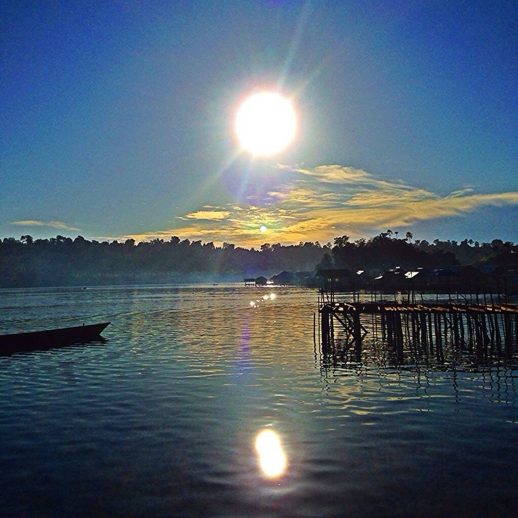 sun, water, tranquil scene, reflection, scenics, tranquility, sunbeam, sunlight, beauty in nature, lake, sunset, lens flare, mountain, nature, sky, waterfront, idyllic, sea, pier, rippled