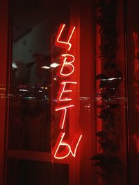 Illuminated text on red glass window