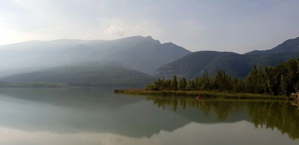 Scenic view of lake and mountains against sky