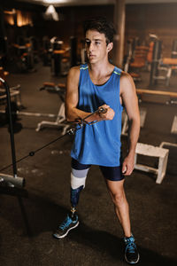 Man with artificial leg exercising in gym