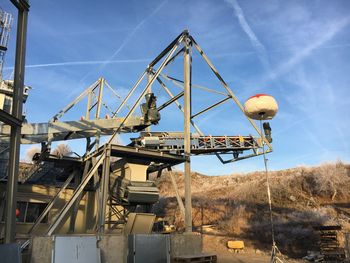 Low angle view of cranes against sky