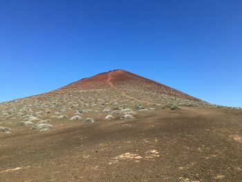 View of desert against clear blue sky