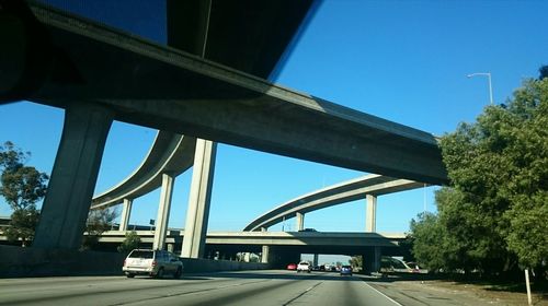Bridge over road against sky in city