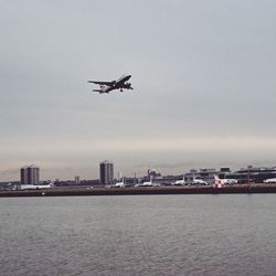 Boats in sea with city in background