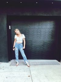 Portrait of woman standing against wall