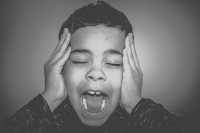 Portrait of teenage boy against gray background