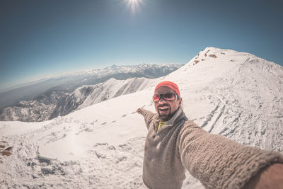 Portrait of man standing on snow covered mountain