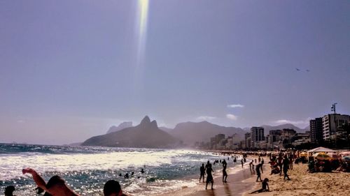 Panoramic view of people on beach against sky