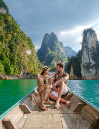 Rear view of woman sitting on boat in sea