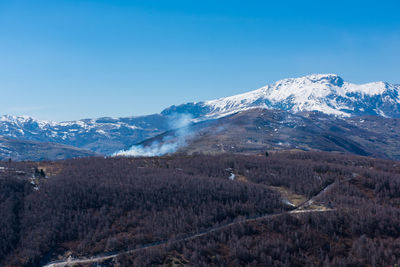 Scenic view of snowcapped mountains against clear blue sky