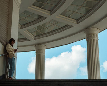 Low angle view of man standing by window