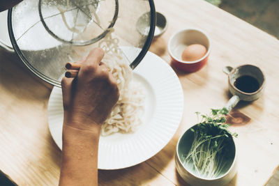 Cropped hand of woman holding food on table