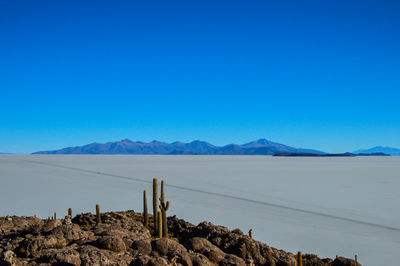 Scenic view of arid landscape against clear blue sky