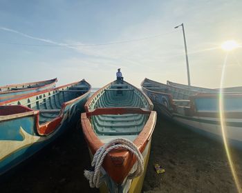 Boats moored at dock against sky during sunset