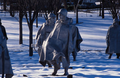 Statues on snow covered land